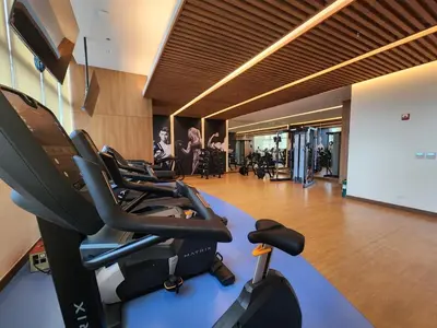a gym with cardio equipment in a large room at Modern 1 br in Park Mckinley West with Breathtaking view fast internet in Manila