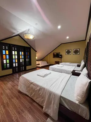 a large bedroom with two beds and a chandelier at La Traviesa Hotel Resort in General Trias