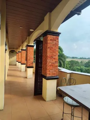 a balcony with brick columns and a table on a roof at La Traviesa Hotel Resort in General Trias