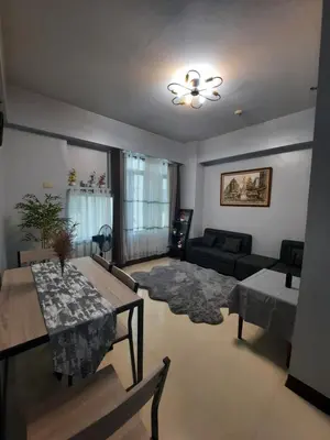 a living room with a table and a couch at Mariz Suites in Manila