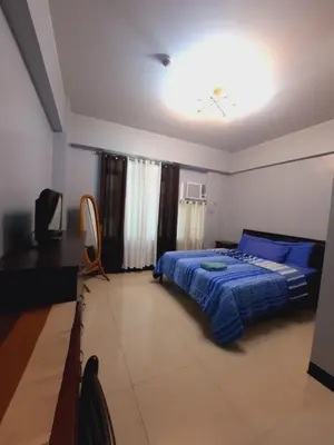 a bedroom with a bed and a clock on the ceiling at Mariz Suites in Manila