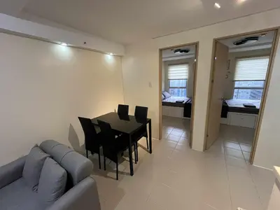 a living room with a couch and a table and chairs at Enzo vibes bnb in Manila