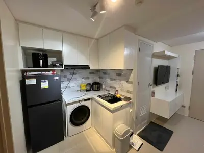 a small kitchen with a black refrigerator and a washer at Enzo vibes bnb in Manila
