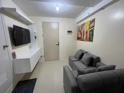 a living room with a couch and a tv at Enzo vibes bnb in Manila