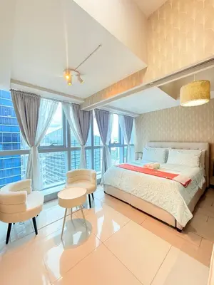 a bedroom with a bed and a table and chairs at Uptown Parksuites Tower 1 in Manila