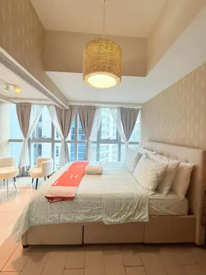 a bedroom with a bed and a large window at Uptown Parksuites Tower 1 in Manila
