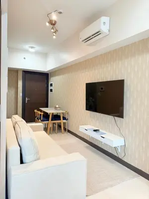a living room with a couch and a flat screen tv at Uptown Parksuites Tower 1 in Manila