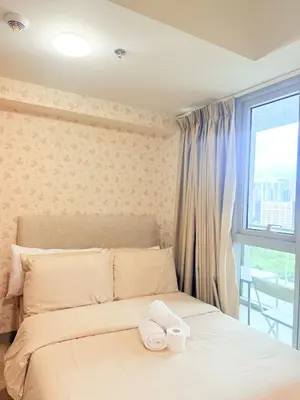 a bedroom with a bed with two towels on it at Uptown Parksuites Tower 2 in Manila