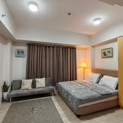 a bedroom with a bed and a couch at Dreamy Condotel Across NAIA Terminal 3 in Manila