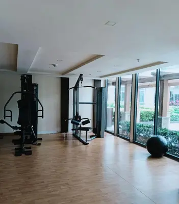 a gym with exercise equipment in a room with windows at Dreamy Condotel Across NAIA Terminal 3 in Manila