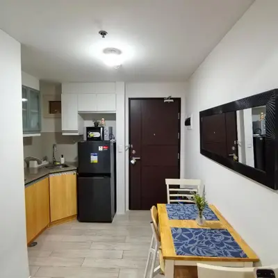 a kitchen with a table and a black refrigerator at Dreamy Condotel Across NAIA Terminal 3 in Manila
