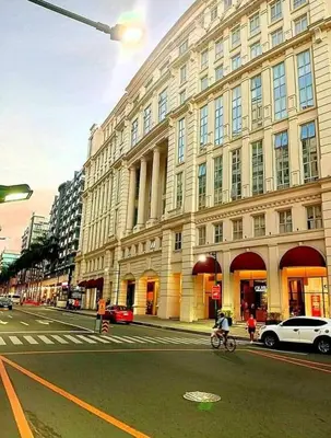 a person riding a bike on a street in front of a building at Dreamy Condotel Across NAIA Terminal 3 in Manila