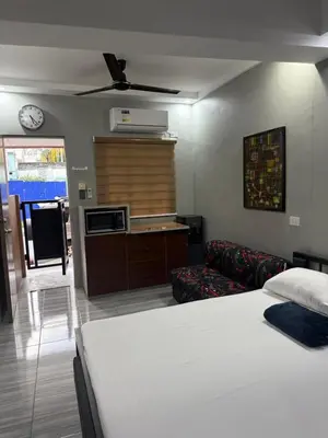 a bedroom with a bed and a couch and a microwave at Studio Room near Circuit Makati in Manila