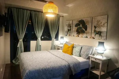 a bedroom with a bed and two lamps and a window at Calming Haven at City Center with Netflix and Hi-Speed Wi-Fi in Manila