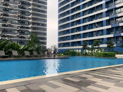 a swimming pool in front of a tall building at Calming Haven at City Center with Netflix and Hi-Speed Wi-Fi in Manila