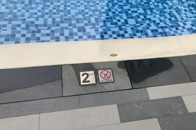 a swimming pool with two signs on the floor at Calming Haven at City Center with Netflix and Hi-Speed Wi-Fi in Manila