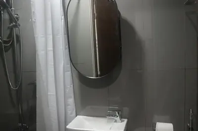 a bathroom with a sink and a mirror and a shower at Calming Haven at City Center with Netflix and Hi-Speed Wi-Fi in Manila