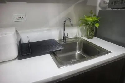 a kitchen counter with a sink and a microwave at Calming Haven at City Center with Netflix and Hi-Speed Wi-Fi in Manila