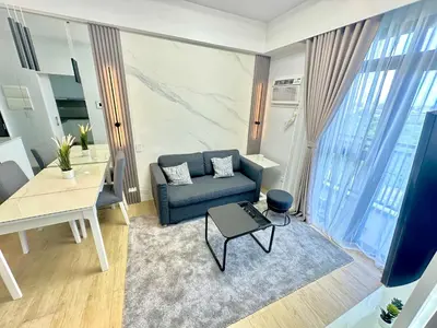 a living room with a blue couch and a table at Stylish Luxe Apt in Gentry Manor in Manila