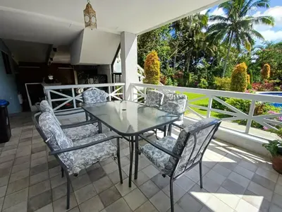a glass table and chairs on a patio at El Casa Azul in Amadeo