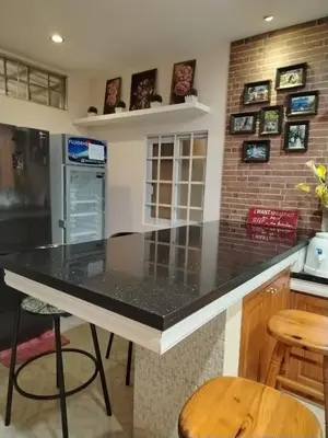a kitchen with a black counter top and a brick wall at El Casa Azul in Amadeo
