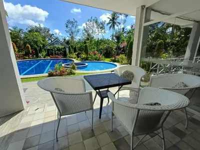 a patio with a table and chairs next to a pool at El Casa Azul in Amadeo