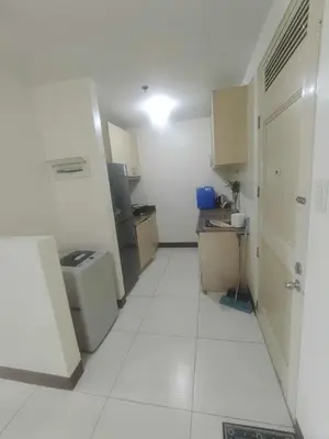 a small kitchen with white floors and a room with a door at Chateau Elysee in Manila