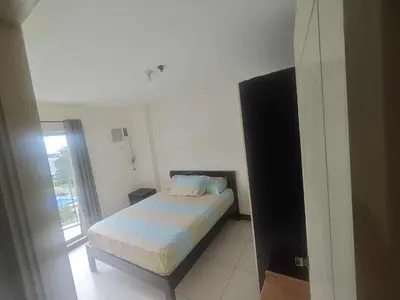 a bedroom with a bed in a room with a window at Chateau Elysee in Manila