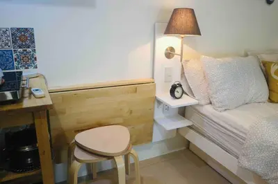 a small bedroom with a bed and a table and a stool at Dreamy Studio with Netflix and High Speed Wifi in Manila