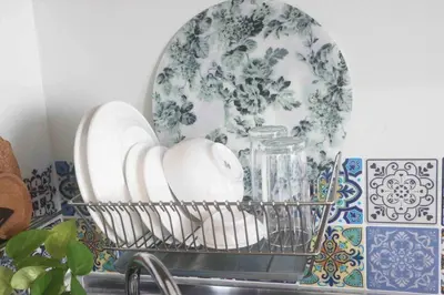 a basket filled with dishes on top of a sink at Dreamy Studio with Netflix and High Speed Wifi in Manila