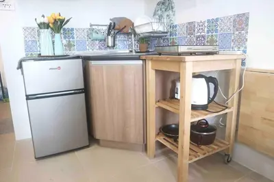 a kitchen with a sink and a refrigerator and a table at Dreamy Studio with Netflix and High Speed Wifi in Manila