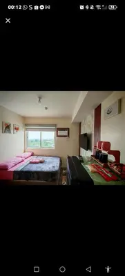 a bedroom with two beds and a window at Family-Friendly 2BR Staycation near Nuvali & Enchanted Kingdom in Puting Kahoy