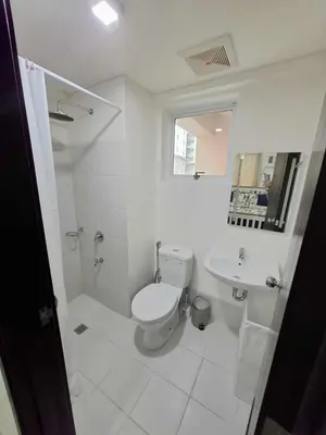 a white bathroom with a toilet and a sink at Comfortable 3-Bedroom Stay in Pasig The Rochester in Manila
