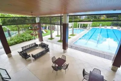 an empty lobby with a pool and tables and chairs at Comfortable 3-Bedroom Stay in Pasig The Rochester in Manila