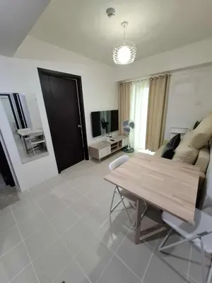 a living room with a table and a couch at Comfortable 3-Bedroom Stay in Pasig The Rochester in Manila