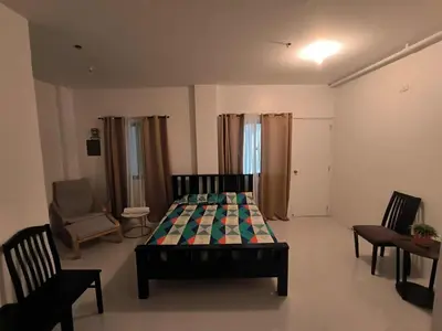 a bedroom with a bed and a couch and a chair at Yujia Apartment in Manila