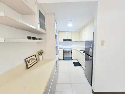 a kitchen with white walls and white appliances at The Infinity Towers in BGC - Spacious 2 Bedroom - View, Washer, Fast WiFi in Manila