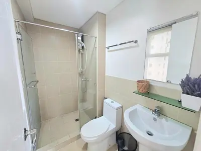 a bathroom with a toilet and a shower and a sink at The Infinity Towers in BGC - Spacious 2 Bedroom - View, Washer, Fast WiFi in Manila