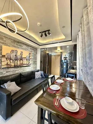 a living room with a couch and a dining table at JOYCE LARA Staycation in Manila