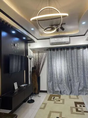 a living room with a television and a chandelier at JOYCE LARA Staycation in Manila