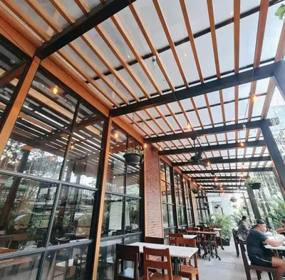 a restaurant with wooden ceilings and tables and windows at BGC 1BR with Fast wifi and Pool use in Manila