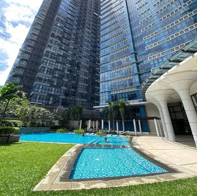 a large swimming pool in front of a tall building at BGC 1BR with Fast wifi and Pool use in Manila
