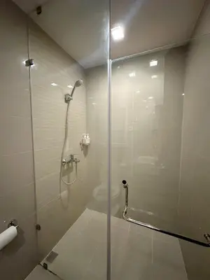 a bathroom with a shower with a glass door at BGC 1BR with Fast wifi and Pool use in Manila