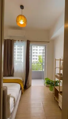 a bedroom with a bed and a large window at Celebrity Stays in Manila
