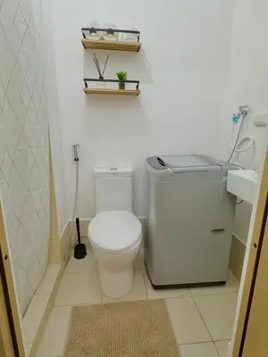 a white bathroom with a toilet and a sink at Celebrity Stays in Manila