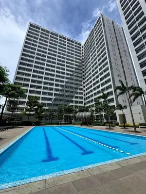 a large building with a blue pool in front of it at Celebrity Stays in Manila