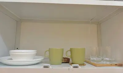 a shelf with three vases and bowls on it at Celebrity Stays in Manila