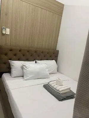 a bed with white sheets and white pillows at Shore residence A41 shortwalk mall of asia in Manila