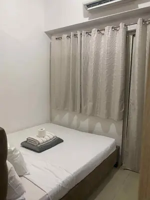 a bed in a room with a window with a cup on it at Shore residence A41 shortwalk mall of asia in Manila