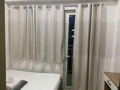 a bedroom with a bed and a window with curtains at Shore residence A41 shortwalk mall of asia in Manila